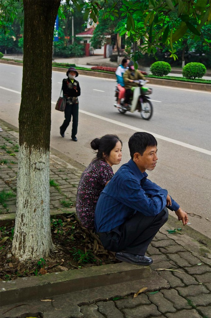 Nguyen Quoc Khanh sits with his wife (?) under a tree in Viet Tri, Vietnam. 2008
