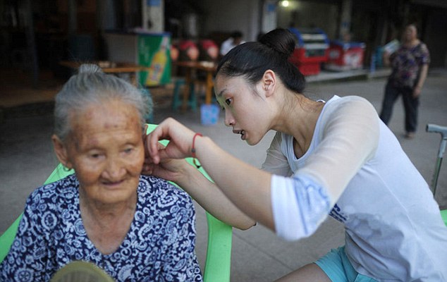 contioutra.com - Quando vai trabalhar, jovem chinesa leva avó nas costas