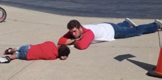 Professor deita no chão para consolar aluno com necessidades especiais que teve dia difícil