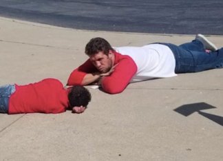 Professor deita no chão para consolar aluno com necessidades especiais que teve dia difícil
