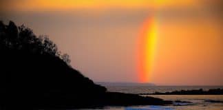 Arco-íris bicolor aparece durante pôr do sol em praia australiana