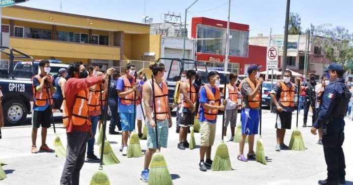 No México, jovens que furam o isolamento social são colocados para varrer as ruas