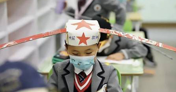 Na China, crianças voltam às aulas com ‘chapéu-helicóptero’ para garantir distância dos colegas