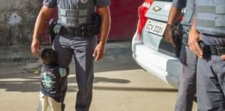 Menininho abraça policial depois de receber cesta básica em Itaquaquecetuba-SP