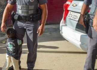 Menininho abraça policial depois de receber cesta básica em Itaquaquecetuba-SP