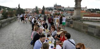 Reunidos em mesa de jantar gigante, moradores de Praga celebram fim da quarentena