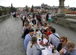 Reunidos em mesa de jantar gigante, moradores de Praga celebram fim da quarentena