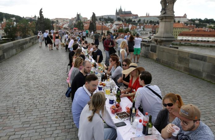 Reunidos em mesa de jantar gigante, moradores de Praga celebram fim da quarentena
