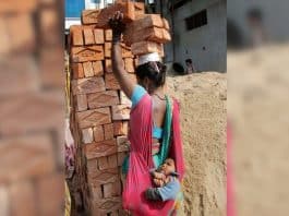 Mãe trabalha carregando tijolos na cabeça com o filho no colo