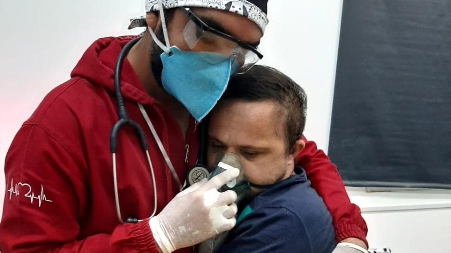 contioutra.com - Enfermeiro abraça paciente com Síndrome de Down para tranquilizá-lo e dar oxigênio no AM