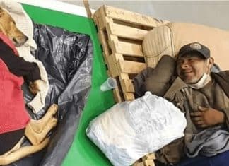 Homem em situação de rua sorri para seu cachorro após abrigo os acolherem em noite fria