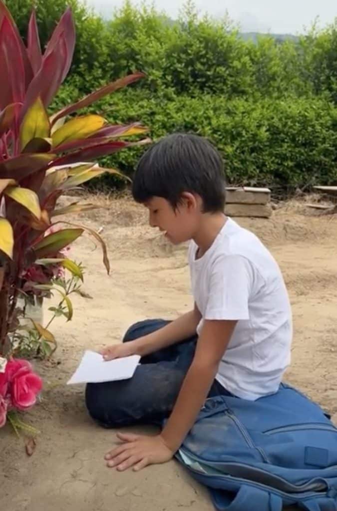 contioutra.com - Menino faz tarefas escolares diante do túmulo da mãe e mostra suas notas: "Ela se orgulha de mim"
